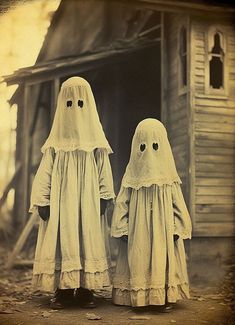 two ghost dolls standing next to each other in front of an old house with the door open