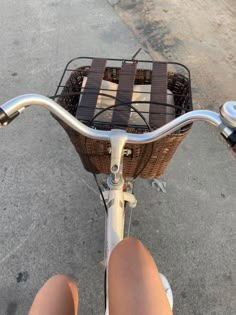 a person riding a bike with a basket on the handlebars and no shoes