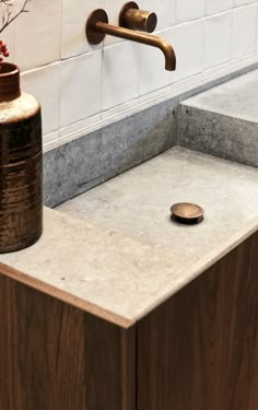 a bathroom sink with a wooden cabinet underneath it and a metal faucet on the side