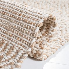 a close up of a rug on the floor with white and brown colors in it