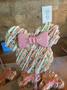 a close up of a cake on a stick with icing and bowknots