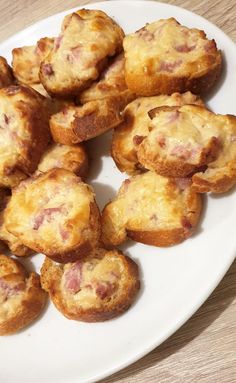 small muffins on a white plate sitting on a wooden table