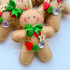 several small teddy bears with green bows and decorations on them are arranged in the shape of an ornament