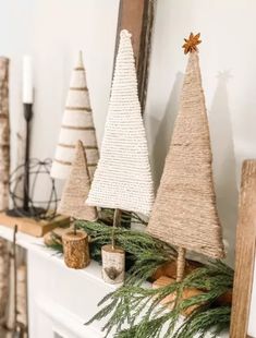 three christmas trees sitting on top of a mantle