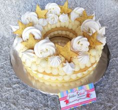 a cake with white frosting and gold stars on top