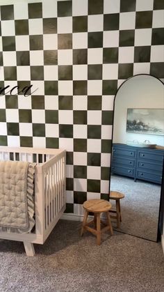 a baby's room with checkered walls and furniture