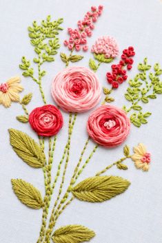 a close up of some embroidery on a piece of cloth with flowers in the middle