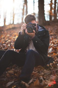 a man is taking a photo in the woods with his camera and it's lens pointed at him