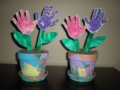 two potted plants with handprints on them