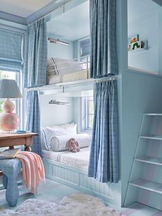 a bedroom with bunk beds and blue curtains on the windowsills is decorated in pastel colors