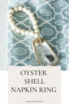 an oyster shell necklace with white beads on it and the words oyster shell napkin ring