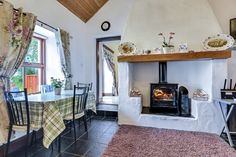 a dining room with a table and chairs next to an open fire place in the fireplace