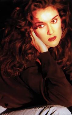 a woman with long curly hair sitting down