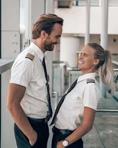 a man and woman in uniform smile at each other