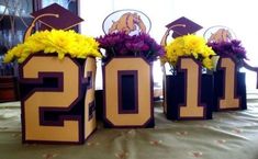 three vases with flowers in them sitting on a table next to the numbers 2012