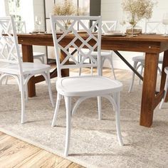 a dining room table with chairs and a rug on the floor