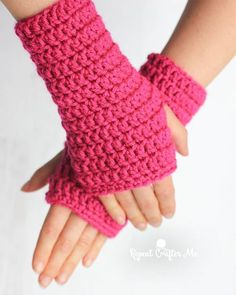 a child's hand wearing pink crocheted fingerless gloves