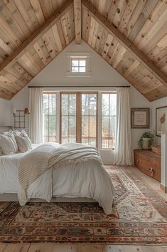 a large bed sitting inside of a bedroom on top of a wooden floor next to a window