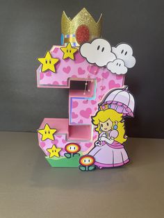 the letter e is made up of cardboard and has princesses on it, including a crown