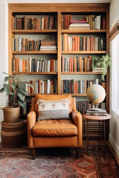 a living room with bookshelves full of books and a leather chair in the corner