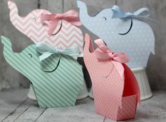 three small elephant shaped boxes with bows on the front and back, one in pink, one in blue