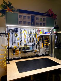 a workbench with lots of tools hanging from it's pegboard on the wall