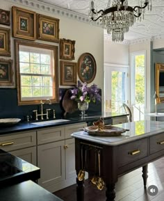 a large kitchen with an island and chandelier hanging from it's ceiling