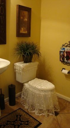 a white toilet sitting next to a sink in a bathroom on top of a tiled floor