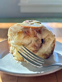 a piece of bread with icing on it and a fork in the foreground