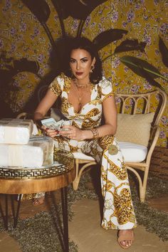 a woman sitting on a chair next to a table with a cake in front of her