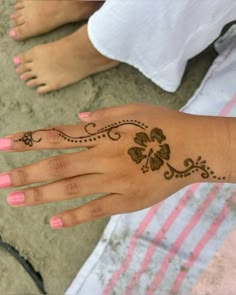 a woman's hand with henna tattoos on it