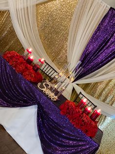 the table is decorated with red flowers and candles for an elegant touch to the room