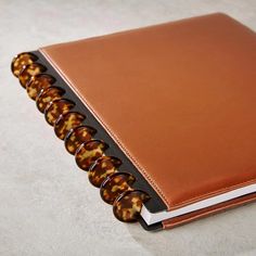 a brown leather binder with tortoiseshells on it