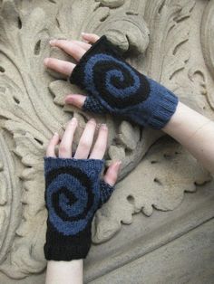 two hands with blue knitted gloves on top of each other