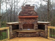 an outdoor fireplace built into the side of a deck