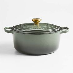 a green casserole with a gold lid on a white background, it is also used as a pot for cooking