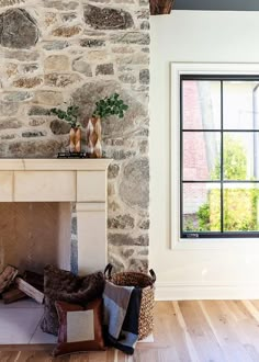 a living room with a stone fireplace and wooden floors