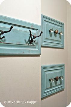 two blue door knobs are attached to the side of a wall with hooks on them