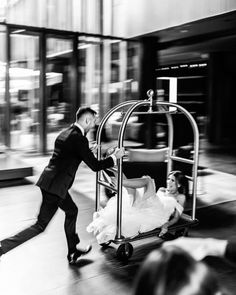 a man pushing a cart with a woman on it