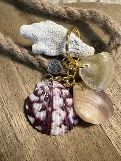 several seashells are hanging on a rope next to some other sea shells and beads