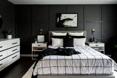 a bedroom with black and white decor in the middle of it, including a large bed