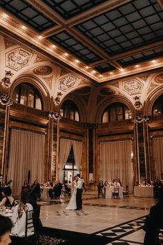 a bride and groom dance in the grand ballroom at their wedding reception