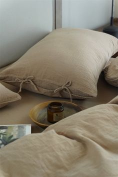 a bed with two pillows and a jar on it