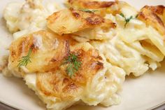 some potatoes are on a white plate and garnished with dill