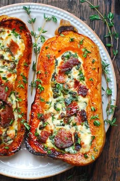 two slices of stuffed sweet potatoes on a white plate with green garnishes