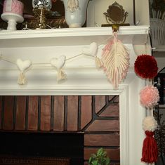 a fireplace mantle decorated with pom - poms and other decorations for valentine's day