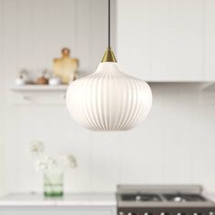 a kitchen with white cabinets and an island in the middle, along with a gold pendant light