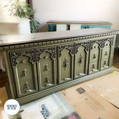 an old dresser is painted green and has ornate carvings on the doors, drawers, and sides