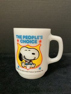 a white coffee mug with a cartoon dog on it's side and the words, the people's choice