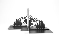 two metal bookends with mountains and trees on them